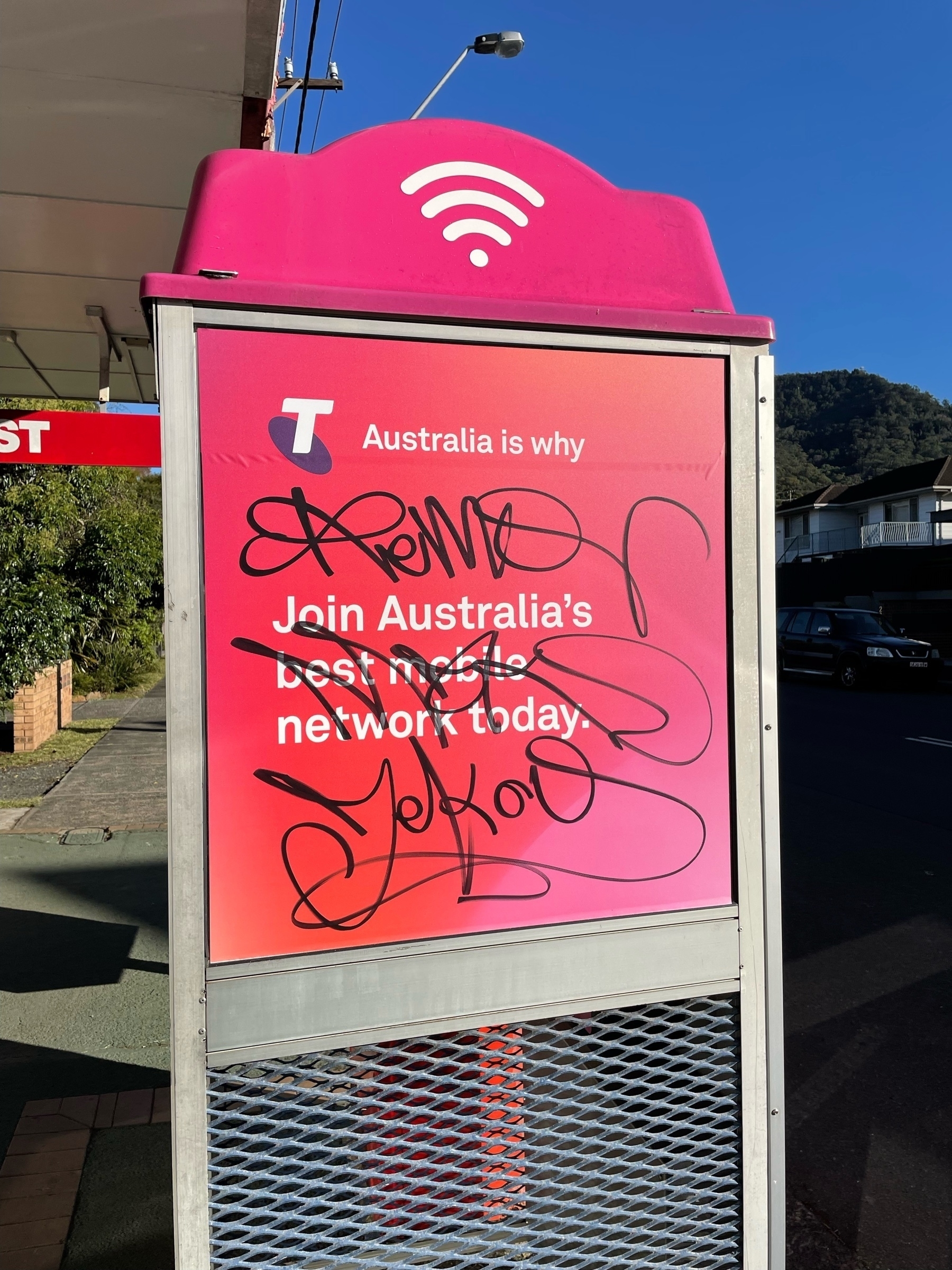 Graffiti on a Telstra phone booth