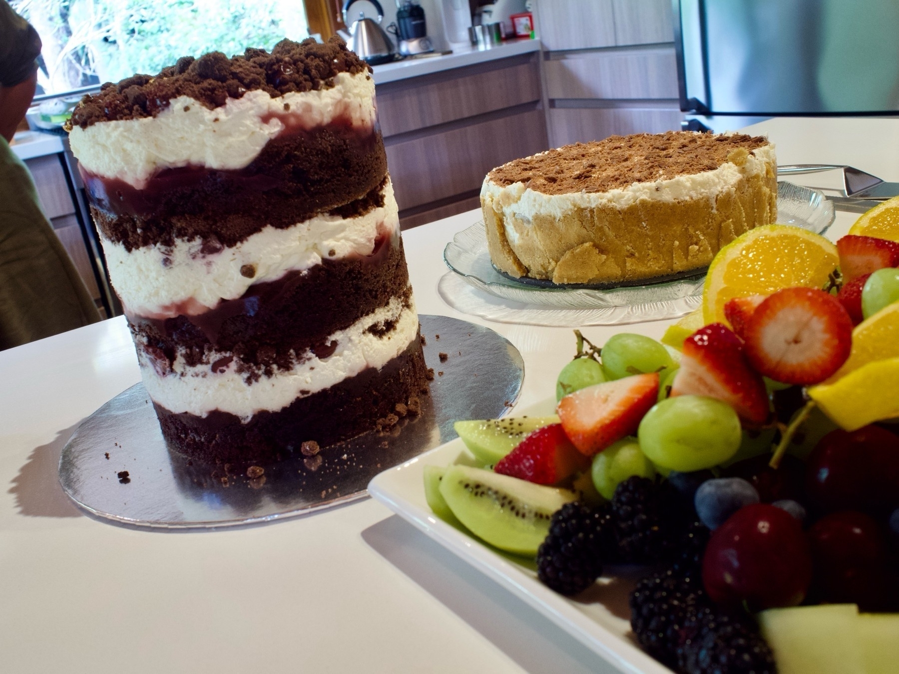 A tall chocolate cake, banoffee pie and fruit platter