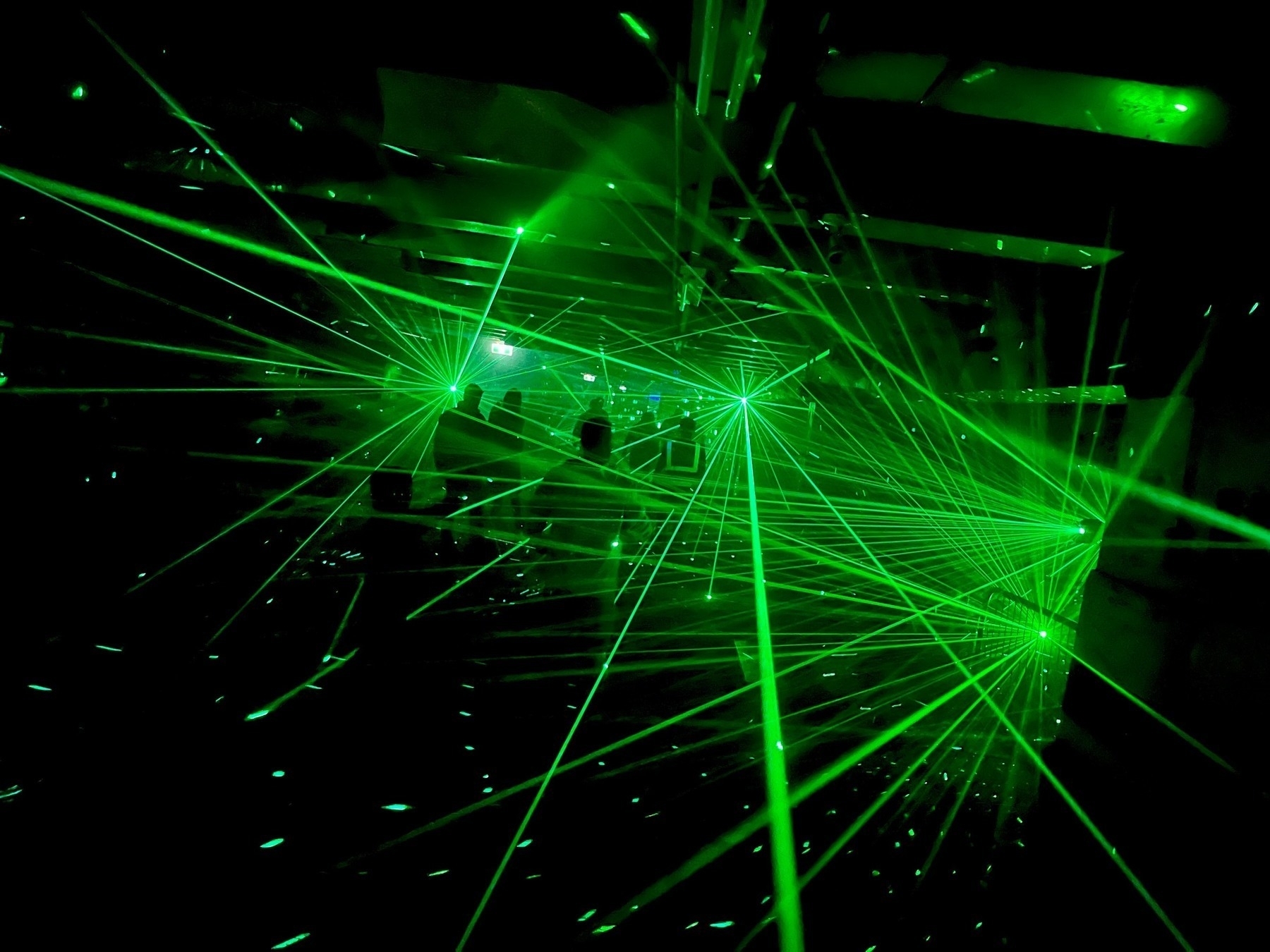 Reflection stage: people's silhouettes among green laser beams