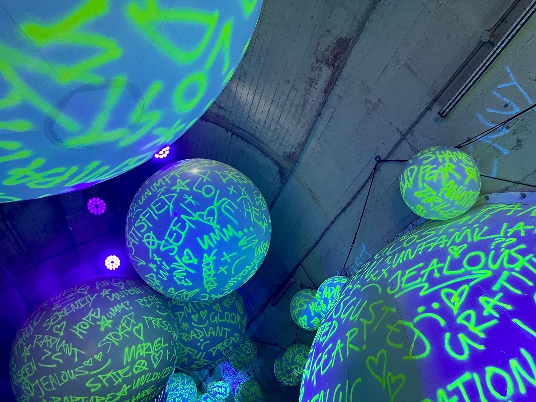 Unseen stage: illuminated, coloured balls displaying writing