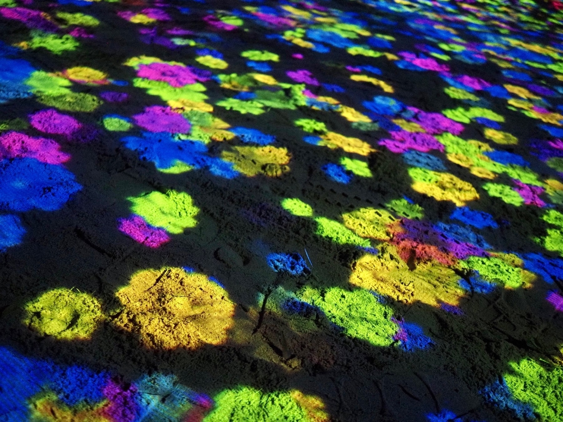 Coloured splodges of light on sand