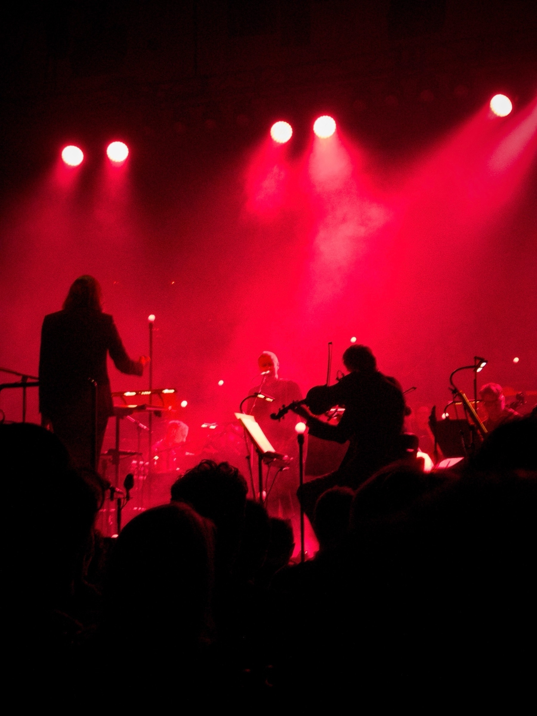 A red glow around Jónsi and other or orchestral musicians