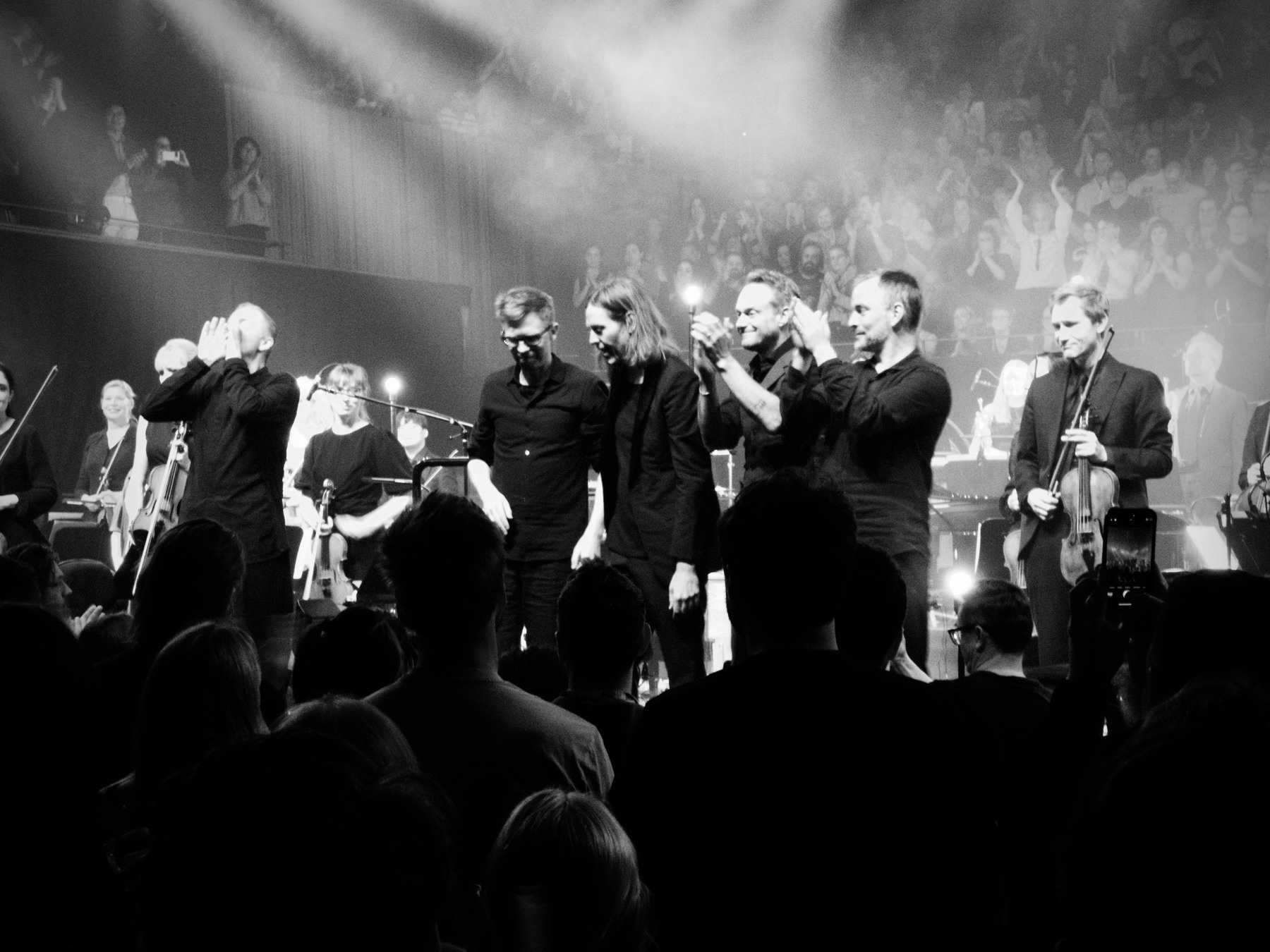 A black-and-white shot of Sigur Rós and the Sydney Symphony Orchestra bowing to applause.