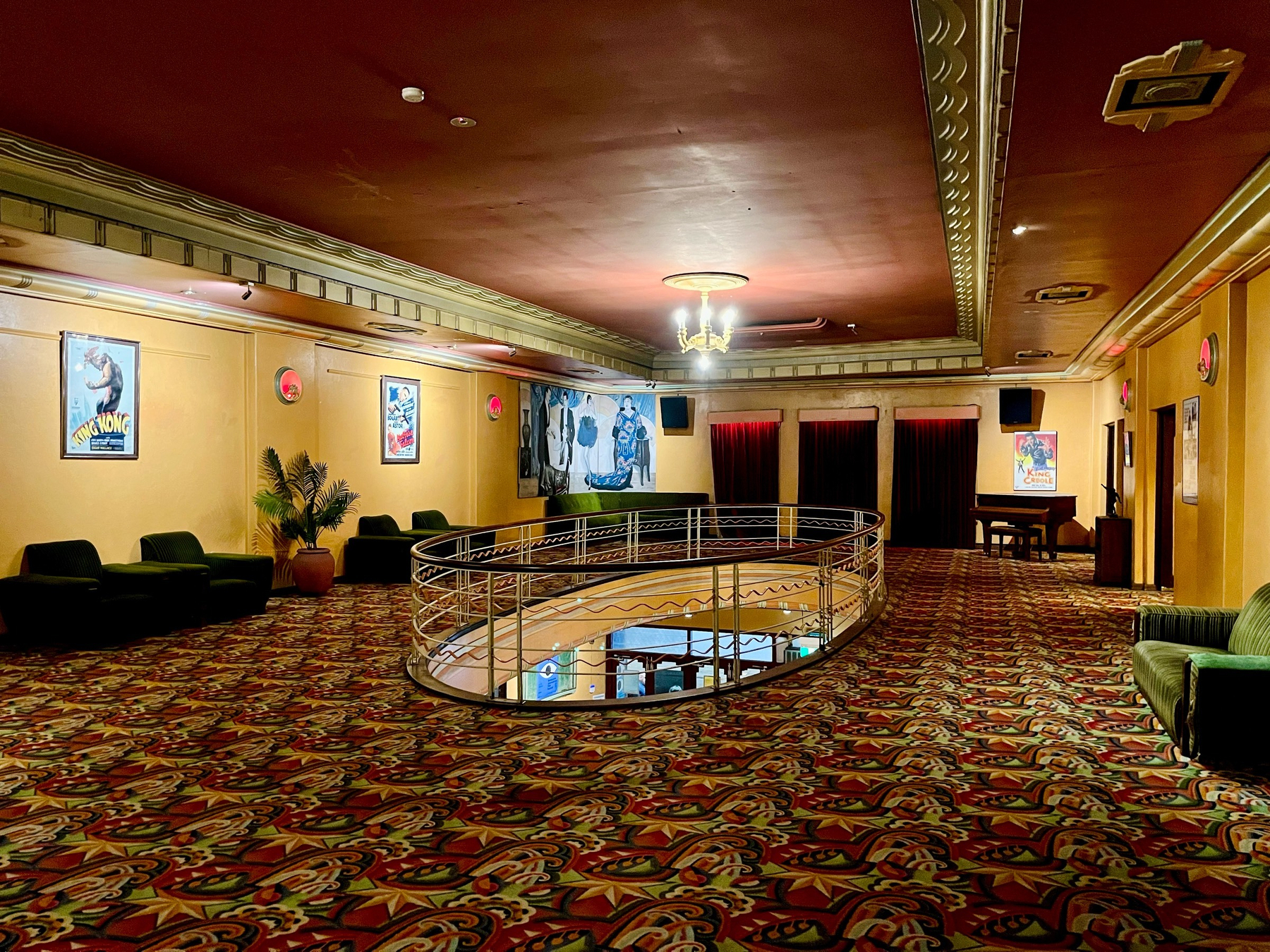 In a classic cinema foyer with an old chandelier dangling above a hole in the floor that reveals the ground level